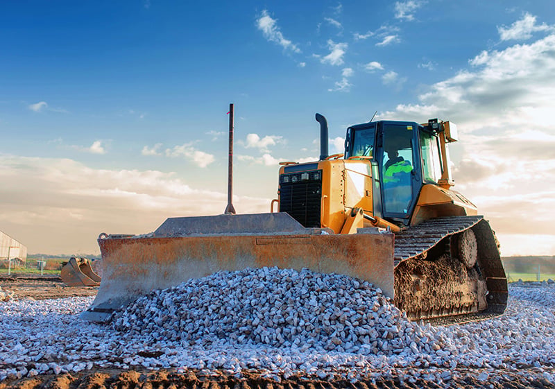 dozer pushing a pile of rocks