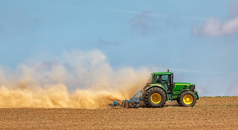 Tractor in a dusy field